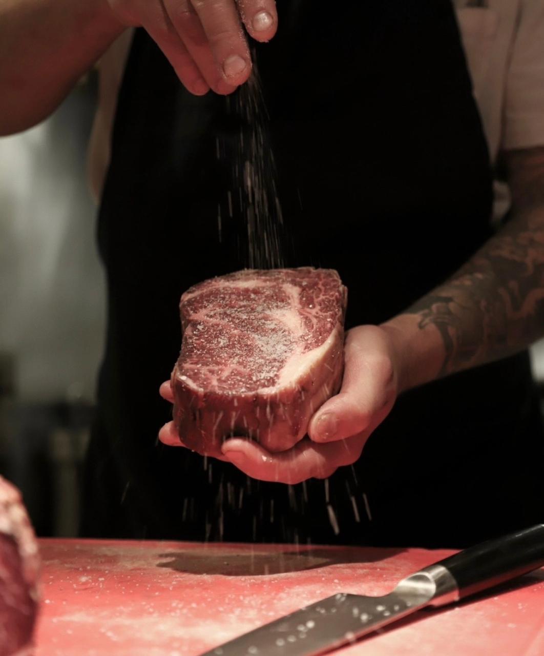 Chef salando el ojo de bife